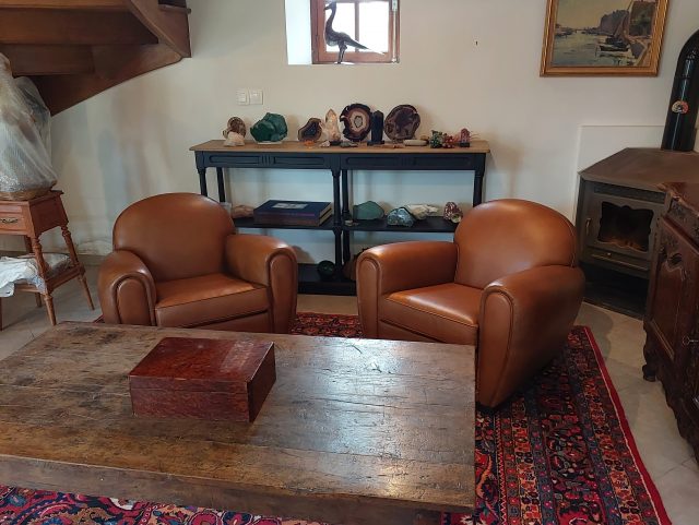 2 fauteuils Club cuir marron Rochembeau dans un salon devant une table basse en bois et tapis