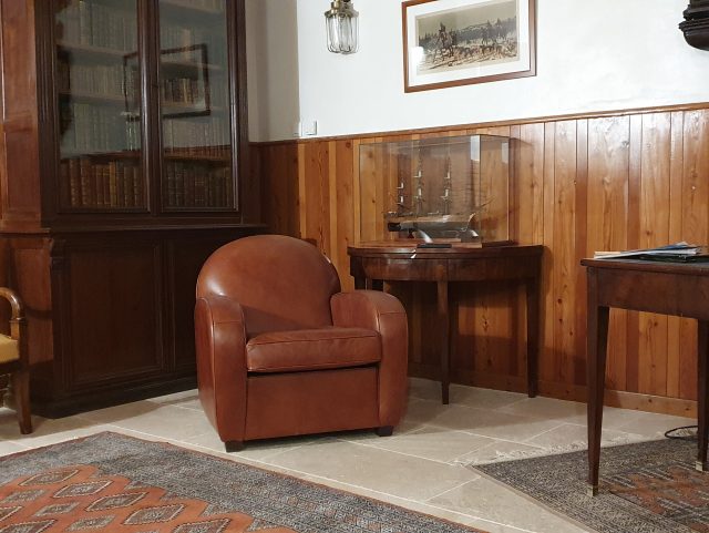 Fauteuil Club cuir Rochembeau dans un itérieur classique bibliothèque vitre et lambris
