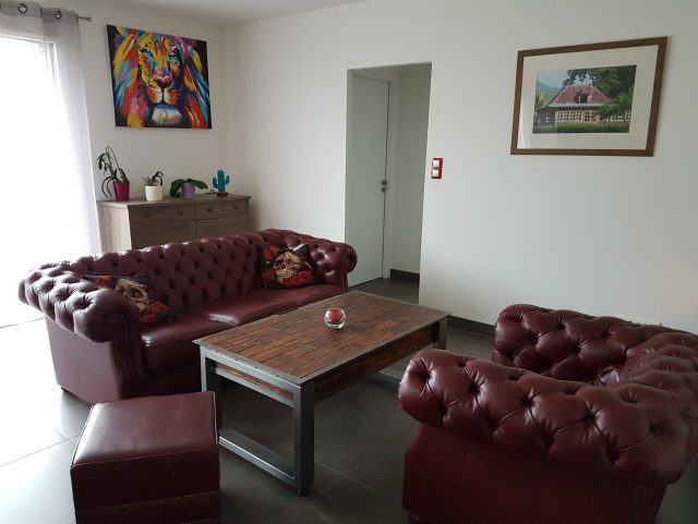 Canapé Chesterfield et fauteuil Chesterfield et pouf cuir Bordeaux Rochembeau dans un salon autour d'une table basse bois et métal