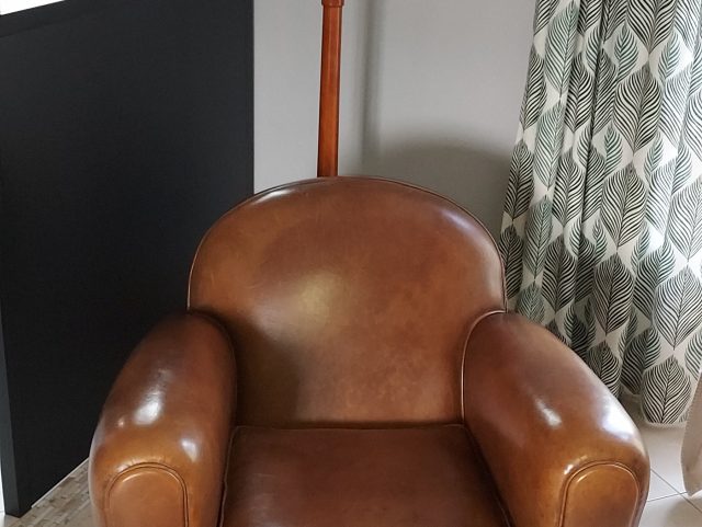 Fauteuil Club cuir marron Rochembeau à côté d'une verrière et d'un porte-manteau bois