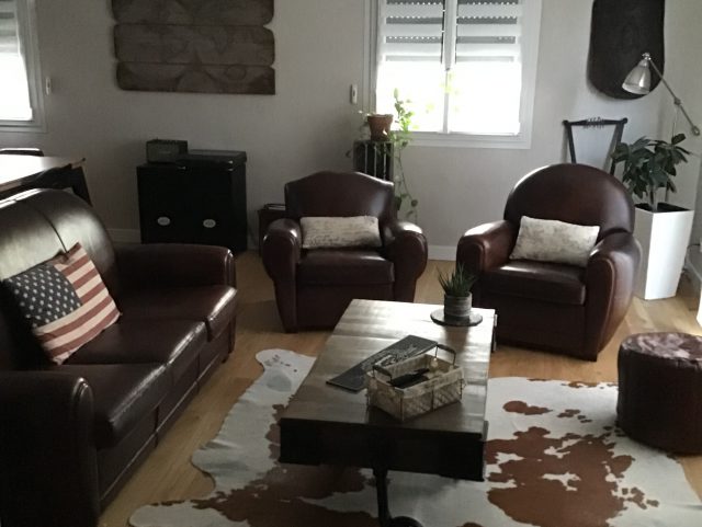 Canapé Club 3 places et deux fauteuils Club cuir marron foncé Rochembeau dans un salon devant une table basse