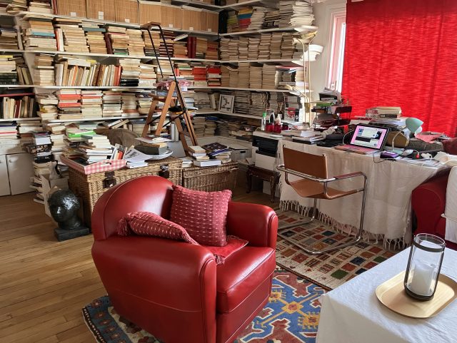 Fauteuil Club cuir rouge Rochembeau devant une grande bibliothèque