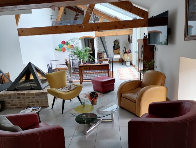 3 faueuils cuir et 1 fauteuil tissus autour d'une table basse en verre