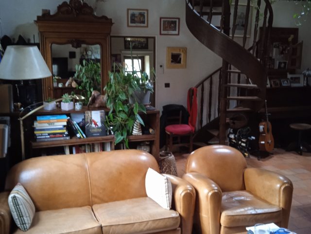 un canapé Club et un fauteuils Club en cuir jaune miel Rochembeau dans un salon devant une table basse en bois