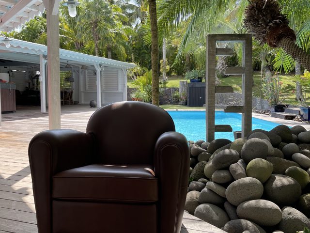 Fauteuil Club Rochembeau devant une piscine en Guadeloupe