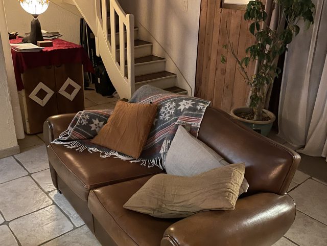 Canapé Club cuir marron Rochembeau devant un escalier