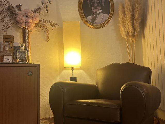 Fauteuil Club moustache en cuir dans un salon devant un lampadaire sur pied